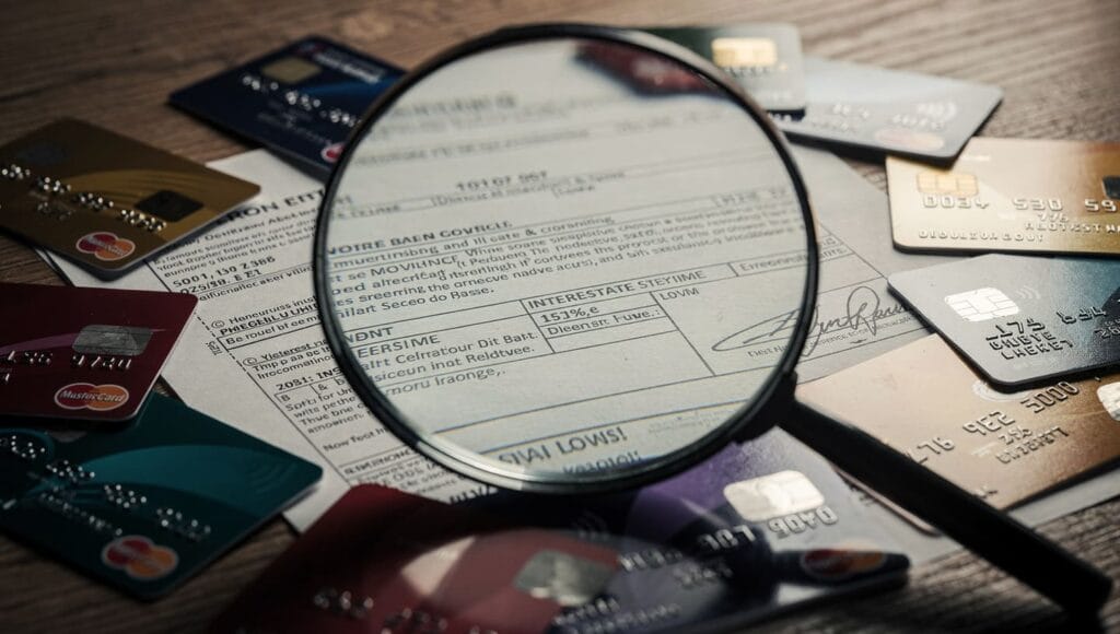 Betrug: Rechtliche Analyse und Schutz Ihrer Rechte 7 credit card and loan documents with a magnifying glass