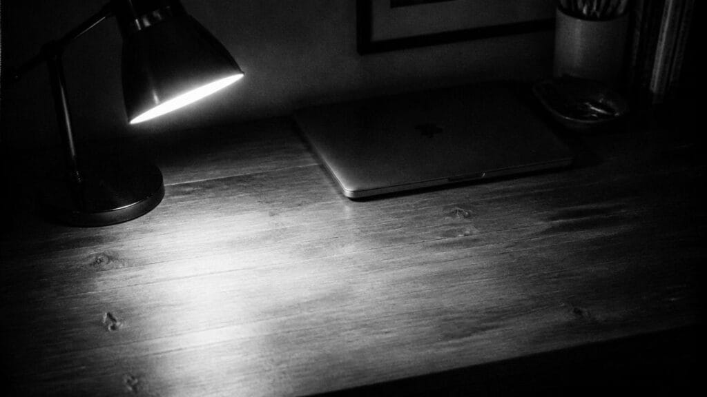 Grainy_black-and-white_documentary_photograph_of_a_home_desk